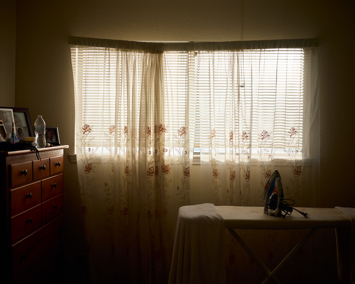 a room with a table and a window with sheer curtains related to Transform Your Bedroom with Texas Flag Bedding