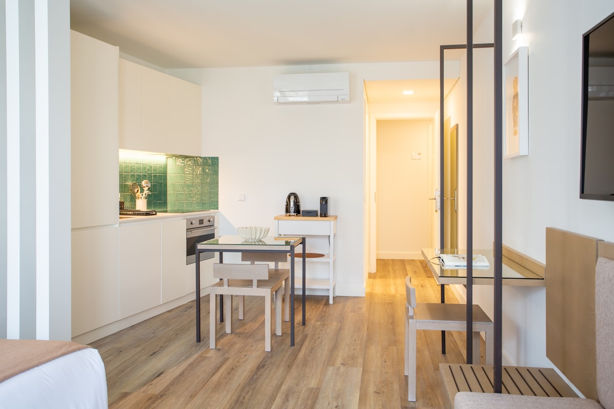 a room with a table, chairs and a television related to Choosing the Perfect Bed for Your Studio Apartment