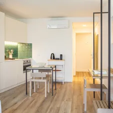 a room with a table, chairs and a television related to Choosing the Perfect Bed for Your Studio Apartment