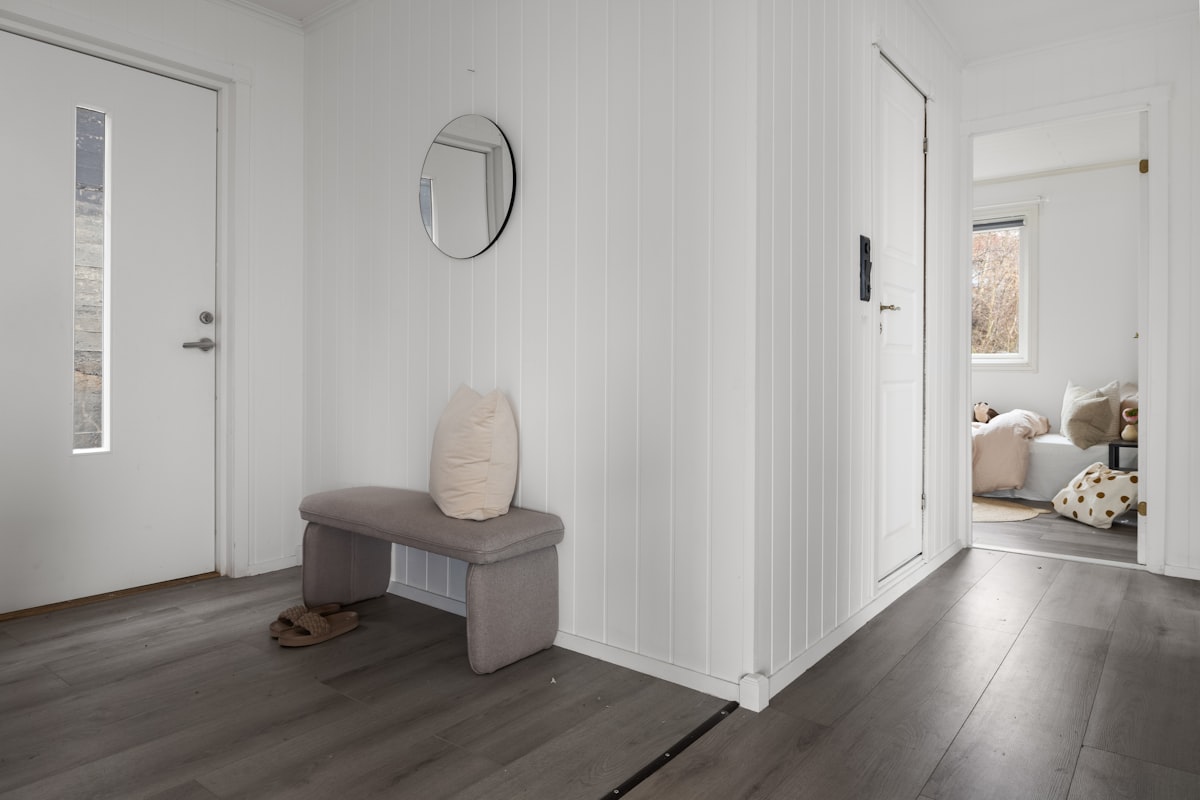 A room with white walls and wood floors related to Cozying Up the Entrance: The Ultimate Guide to Narrow Entryway Benches
