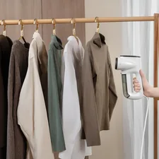 A row of clothes hanging on a wooden rack being effortlessly steamed with a compact vacuum steamer related to Revitalize Your Wardrobe: The Ultimate Guide to Clothes Steamers from Bed Bath & Beyond