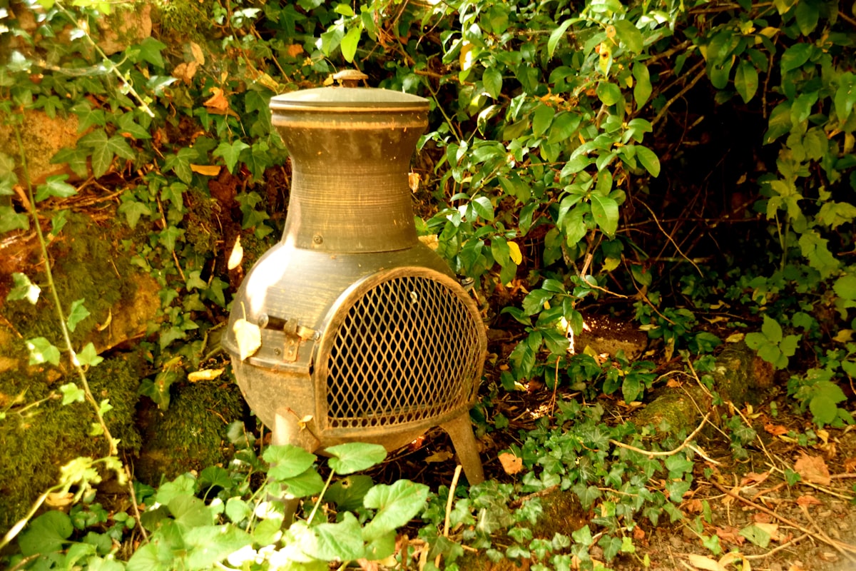 a rusted out stove sitting in the middle of a forest related to Cozy Up with Large Clay Chimineas for Sale