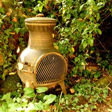 a rusted out stove sitting in the middle of a forest related to Cozy Up with Large Clay Chimineas for Sale