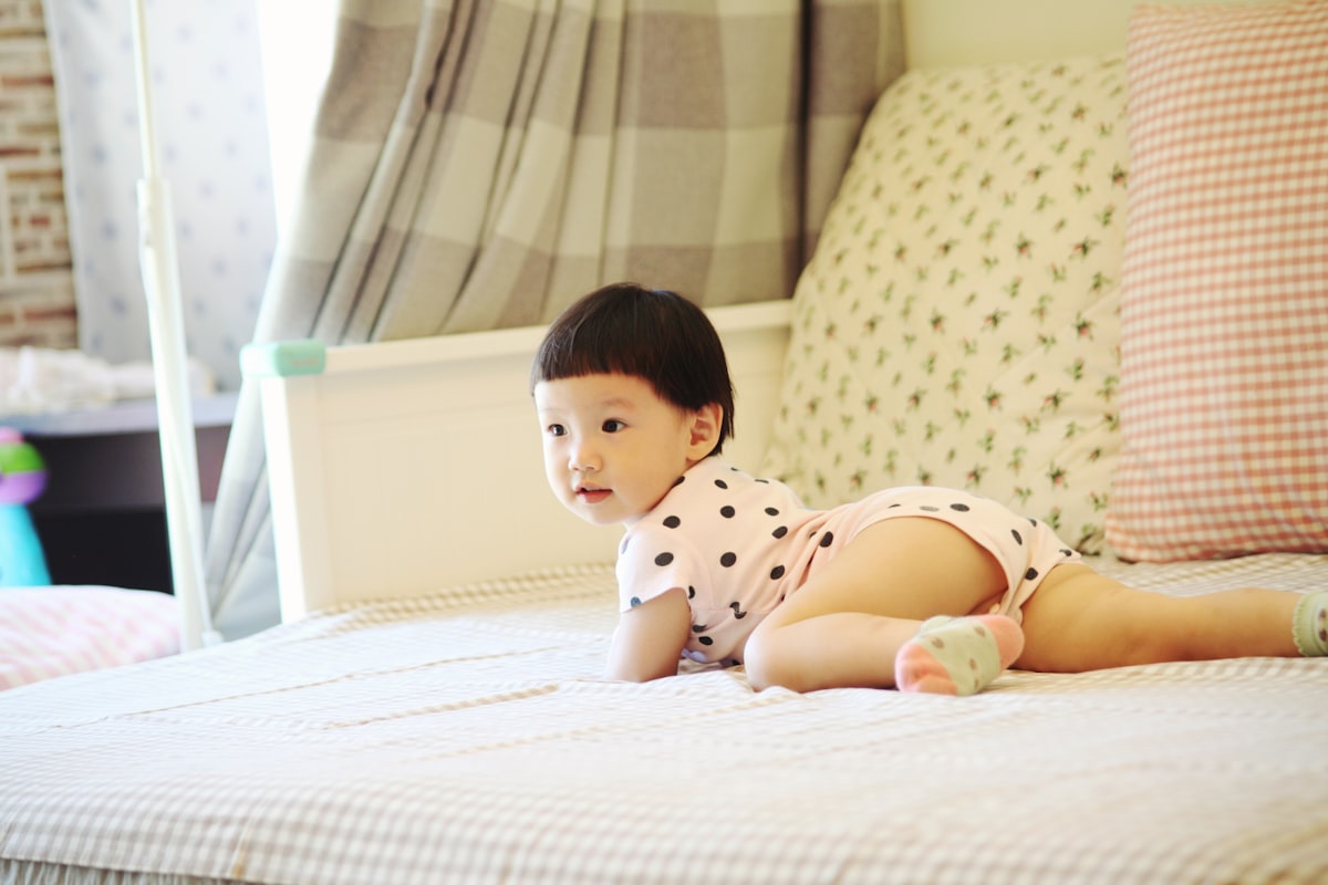 a small child is laying on a bed related to Building Safety: A Guide to DIY Toddler Bed Rails