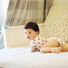a small child is laying on a bed related to Building Safety: A Guide to DIY Toddler Bed Rails