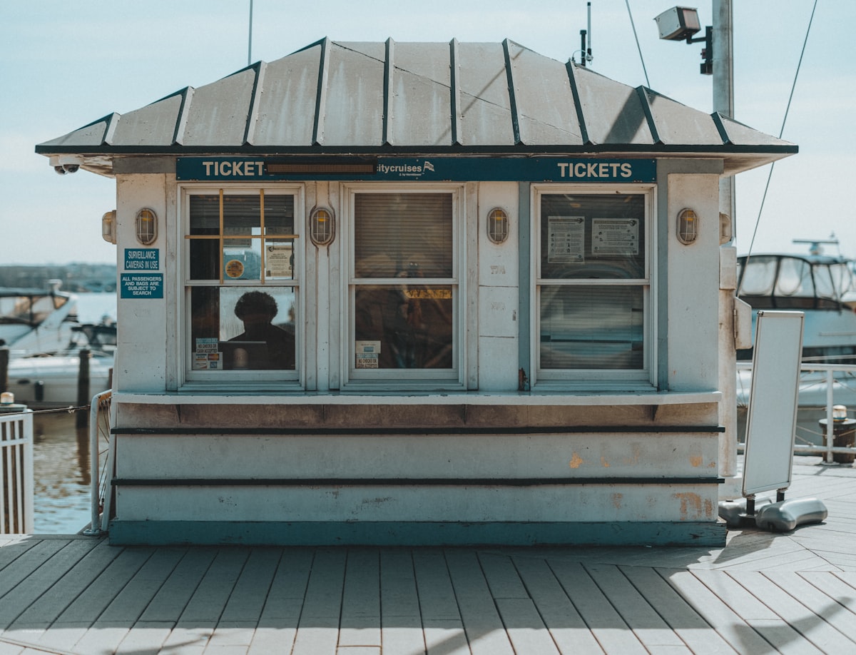 A small ticket booth with a person inside. related to Coastal Window Valances