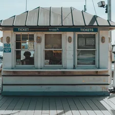 A small ticket booth with a person inside. related to Coastal Window Valances