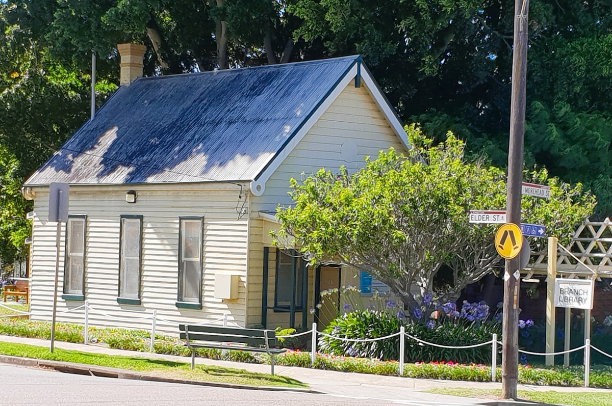 A small white house sitting on the side of a road related to Blossoming Corner Oasis