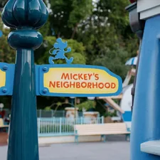 a street sign in front of a playground related to Cozy Up with Mickey: The Ultimate Bedroom Experience