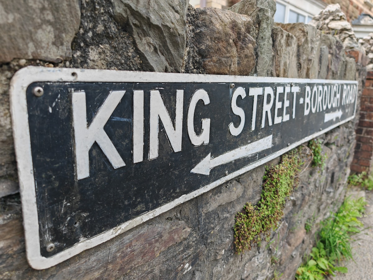 a street sign mounted to a stone wall related to King Coverlets On Sale