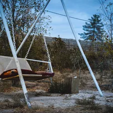 a swing chair sitting in the middle of a field related to Transform Your Home with Affordable Swing Beds for Sale