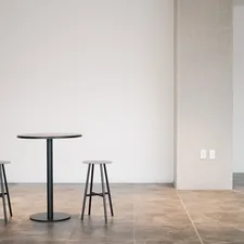 a table and two stools in a room related to Round Entryway Tables: Embrace Elegance and Functionality