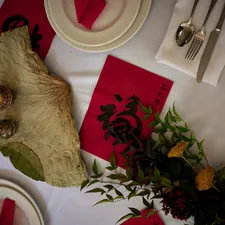 A table is set with red napkins and silverware related to Elegant Dining Experience: The Red Buffet Sideboard