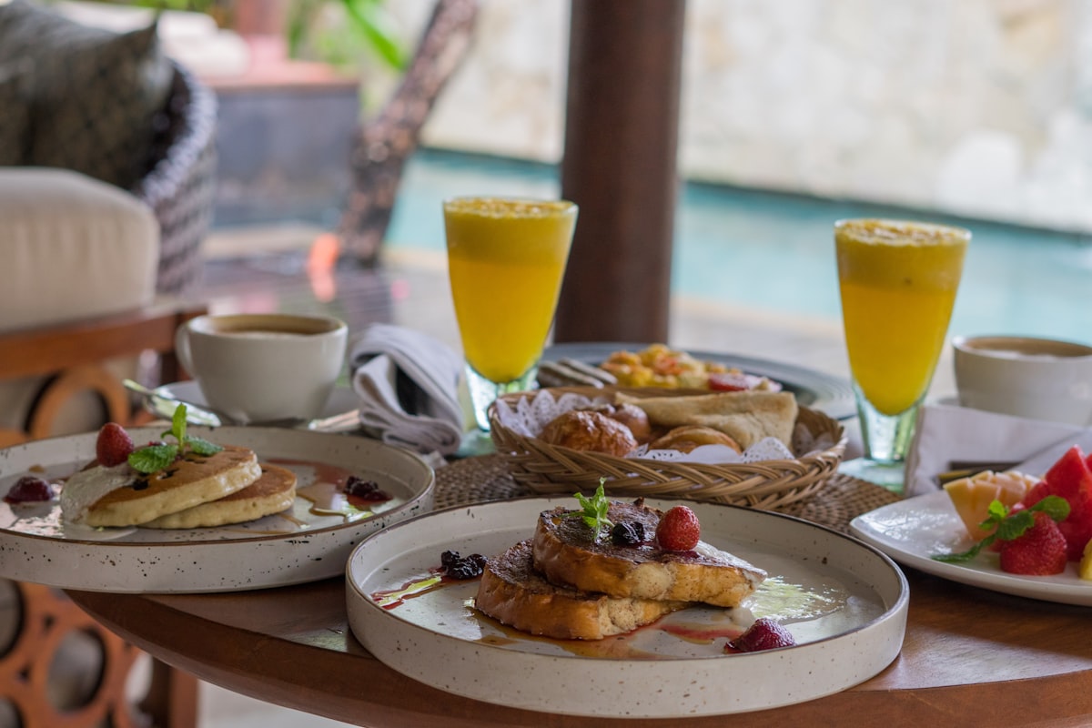 A table topped with plates of food and drinks related to Charming Stays by the Bay