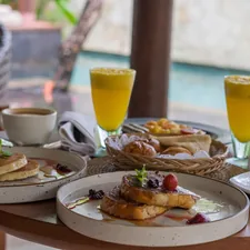 A table topped with plates of food and drinks related to Charming Stays by the Bay