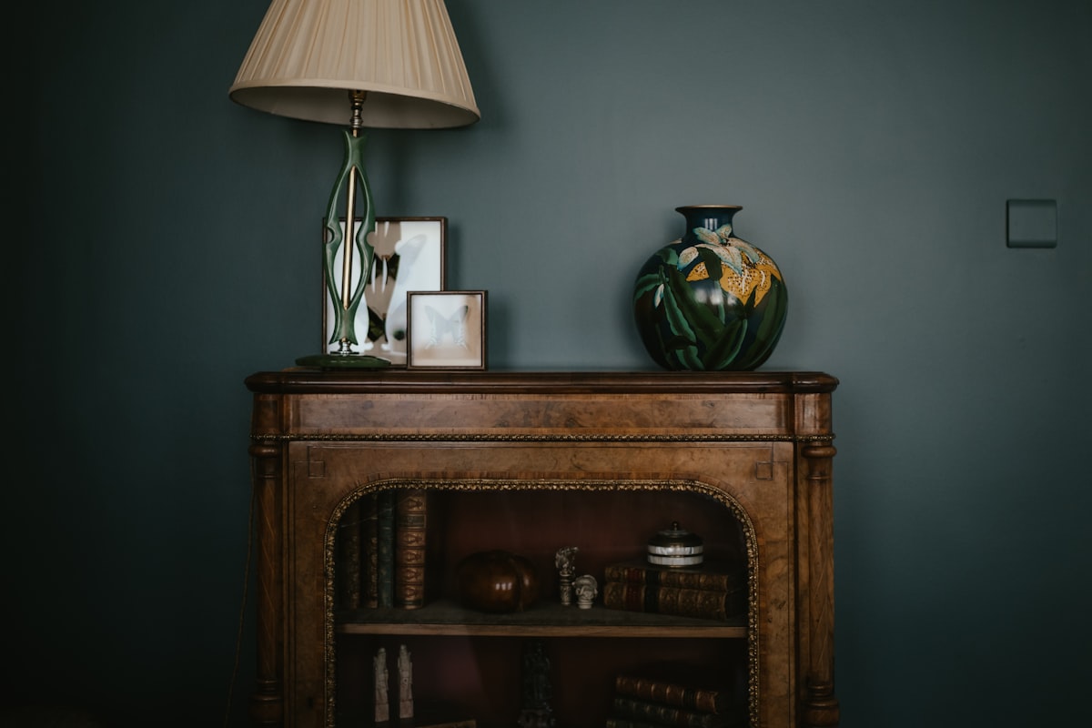 a table with a lamp and a vase on top of it related to Elevate Your Home Decor: The Timeless Charm of Vintage Sideboards and Buffets