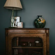a table with a lamp and a vase on top of it related to Elevate Your Home Decor: The Timeless Charm of Vintage Sideboards and Buffets