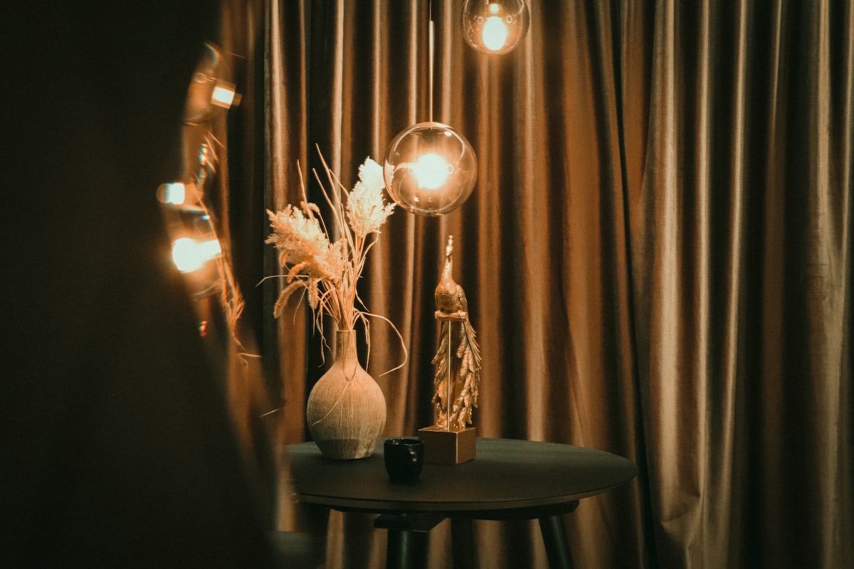 a table with a vase and some lights on it related to Complete Your Home Decor with Drapes and Matching Valances