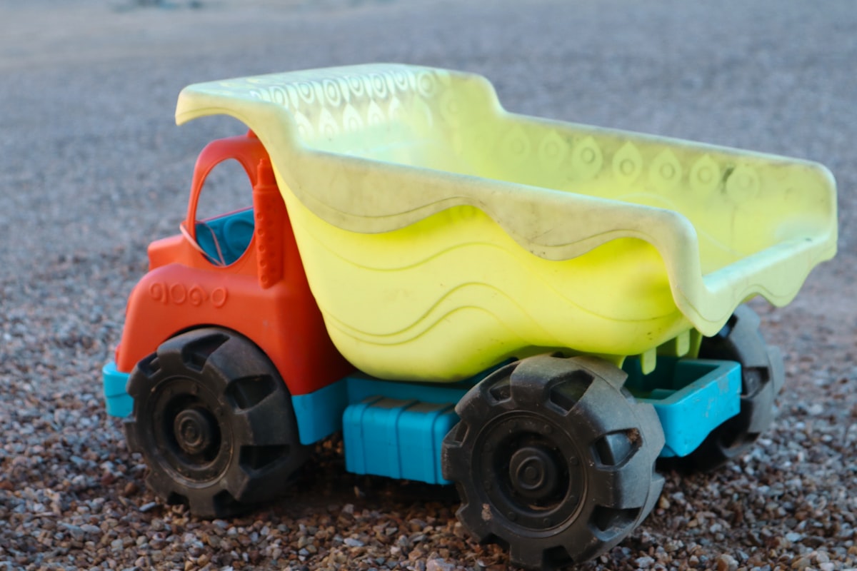 a toy dump truck with a plastic dumpster in the back related to Transform Your Toddler's Room with a Dump Truck Toddler Bed