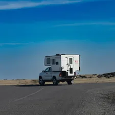 a truck driving down a road with a camper on the back related to Exploring Spacious RV Options for Families