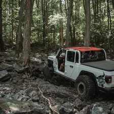 a truck driving through a forest related to Protect Your Ride: The Ultimate Guide to Bed Covers For Trucks