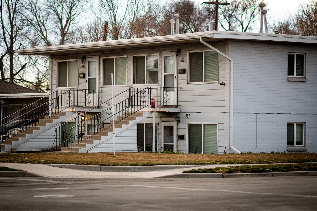 a two story white building with stairs leading up to it related to Find Your Perfect 2-Bed Apartment for Rent: Affordable Living Solutions