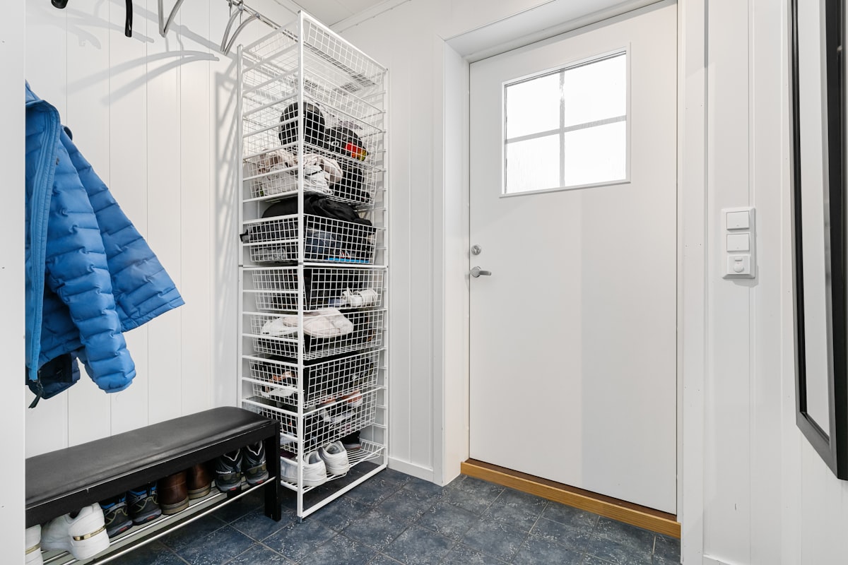 A walk in closet with a coat rack and shoes related to Elevate Your Entryway: The Ultimate Guide to Entryway Shoe Benches