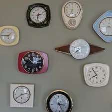 a wall with many different clocks on it related to The Ultimate Guide to Clocks from Bed Bath & Beyond
