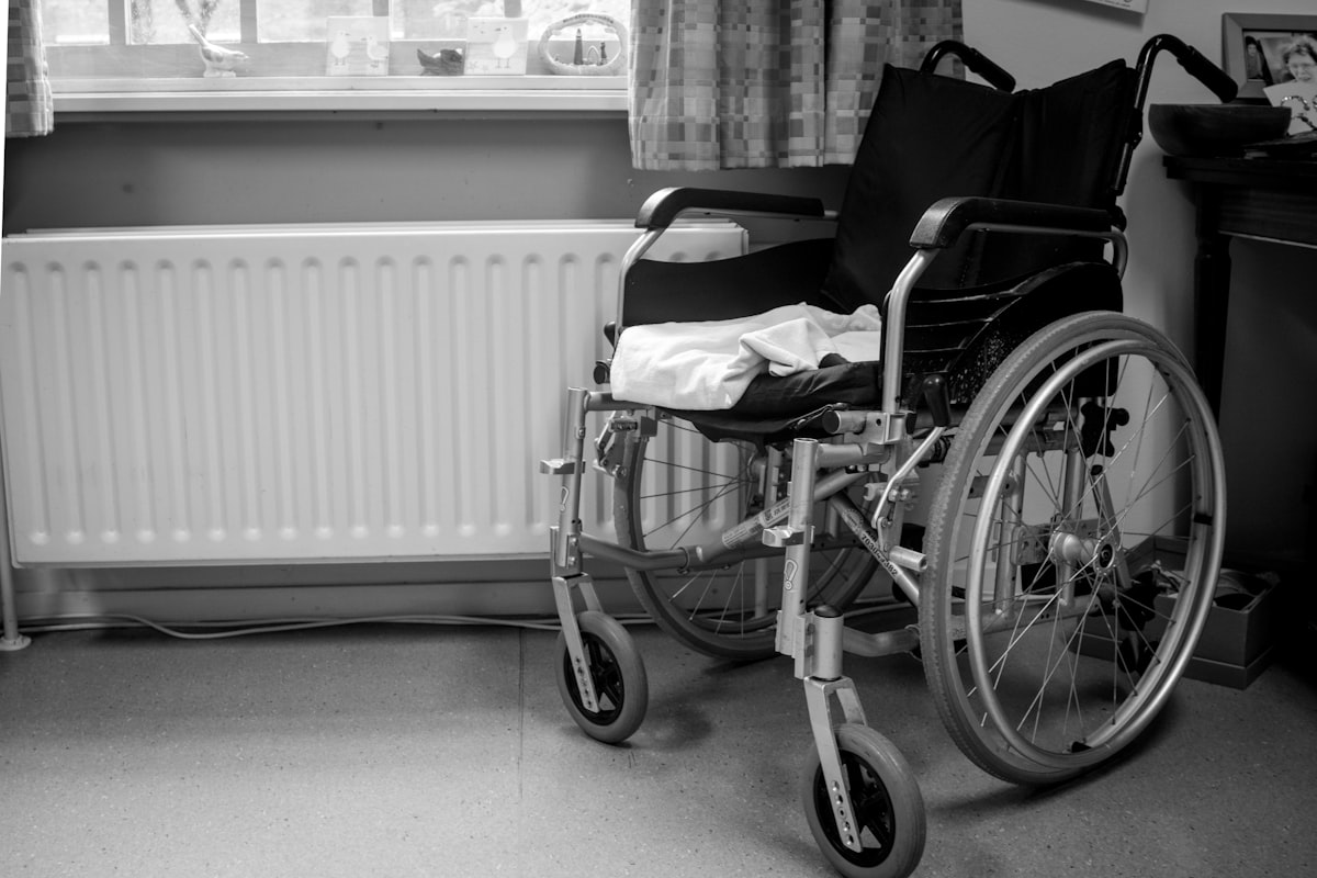 a wheelchair sitting in a room next to a radiator related to Finding Comfort and Safety in the Shower: A Guide to Shower Chairs at Bed Bath and Beyond