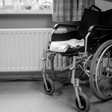 a wheelchair sitting in a room next to a radiator related to Finding Comfort and Safety in the Shower: A Guide to Shower Chairs at Bed Bath and Beyond