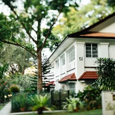 a white house with a red roof surrounded by trees related to Discover the Charm of Amber House Bed & Breakfast