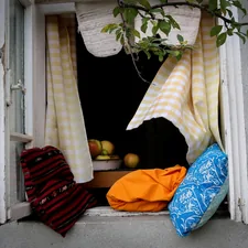a window sill with a bunch of cloths hanging out of it related to Scarf Valance: Creative Window Treatment Ideas