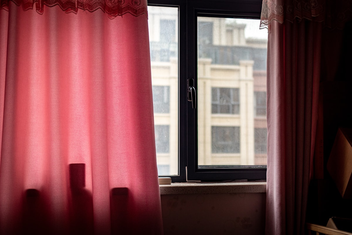 a window with red curtains related to Elevate Your Windows with Curtain Swags and Valances