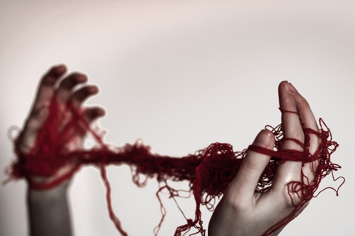 A woman holding a red string in her hands related to Snuggle Up in Style: Unraveling the Mystery of Duvet Coverlets