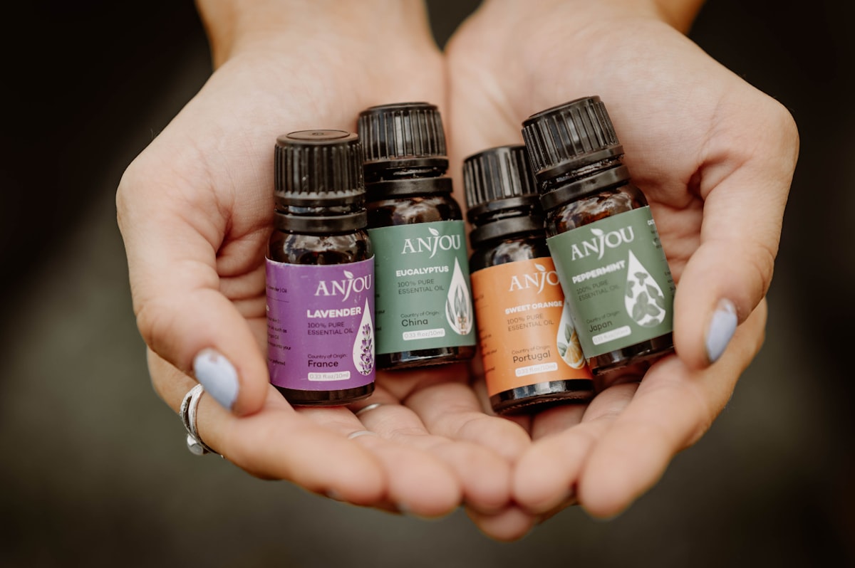a woman holding four bottles of essential oils in her hands related to Does Peppermint Oil Repel Bed Bugs? The Truth Behind the Myth