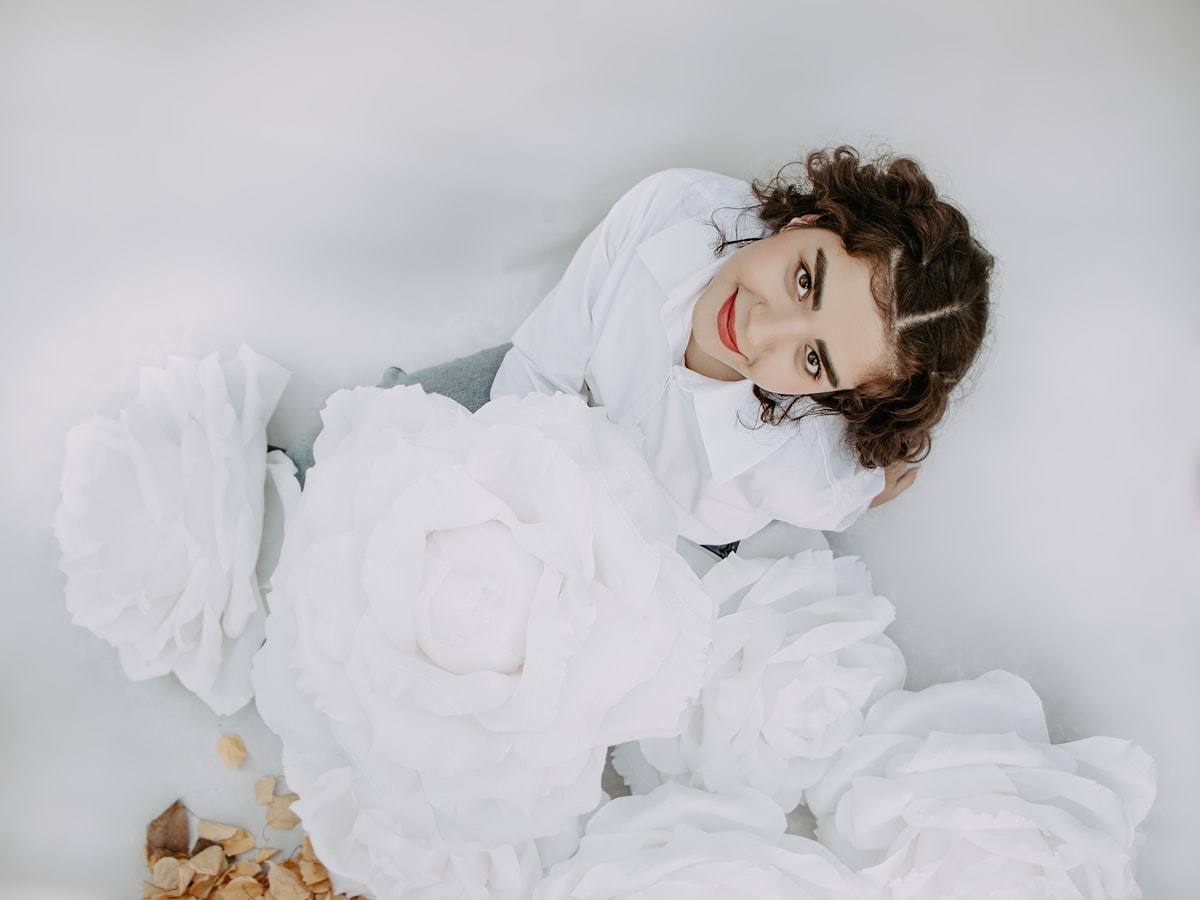 a woman in a white dress laying on a bed of white flowers related to Bed Bath & Beyond Wedding Registry: A Comprehensive Guide