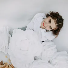 a woman in a white dress laying on a bed of white flowers related to Bed Bath & Beyond Wedding Registry: A Comprehensive Guide