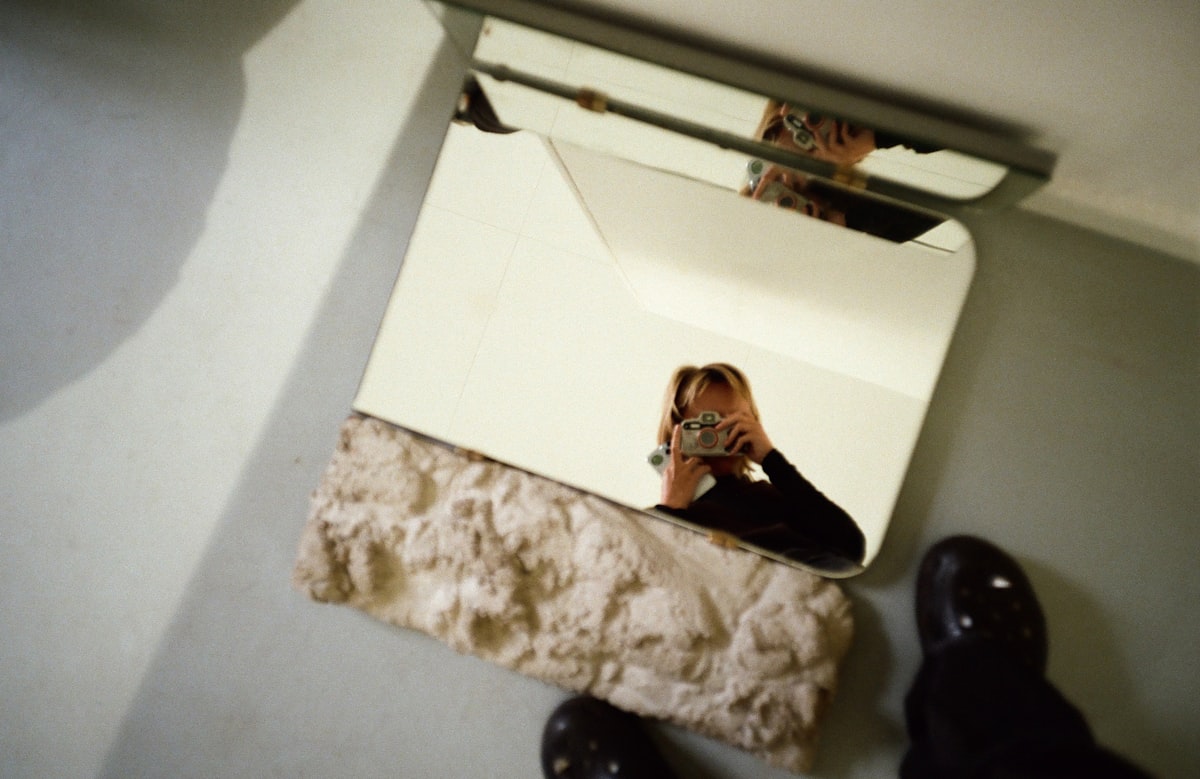 A woman is taking a picture of herself in a mirror related to Bed Bath & Beyond Mirrors: Find the Perfect Mirror for Your Bathroom