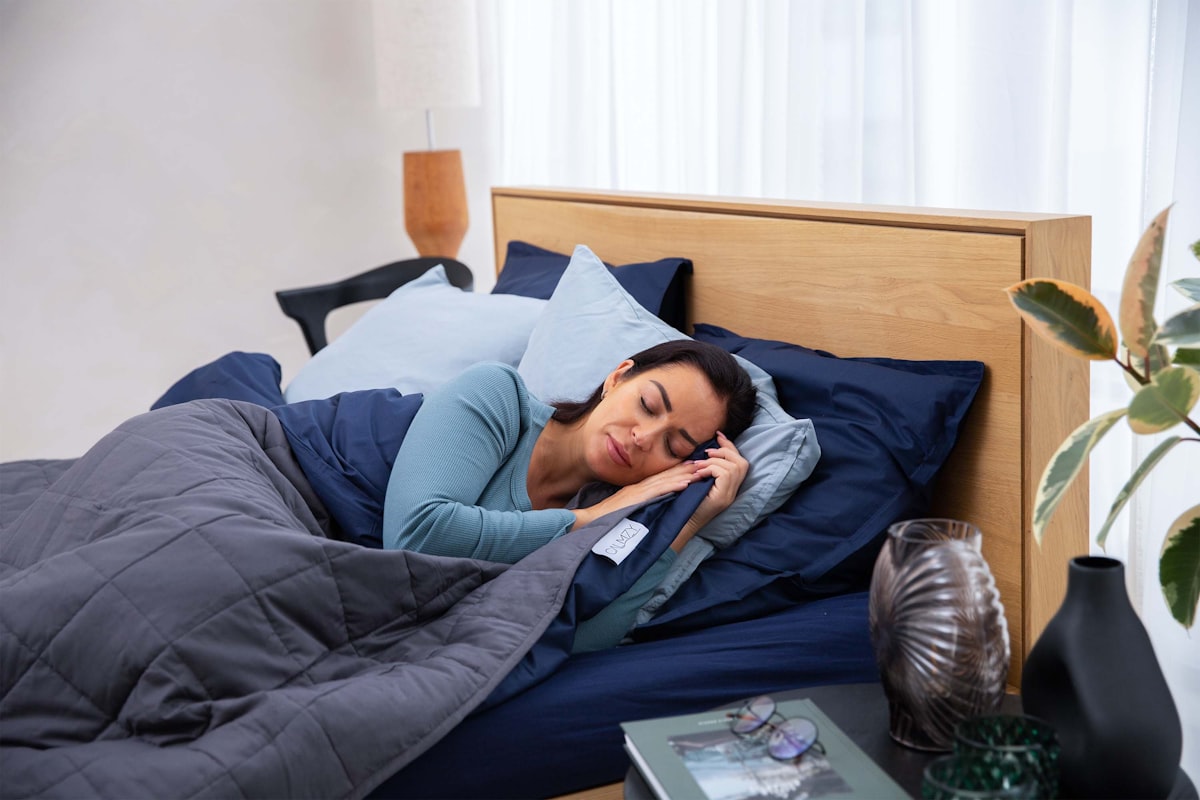 a woman laying in bed talking on a cell phone related to Soft and Cozy: The Best Cotton Coverlets for Beds