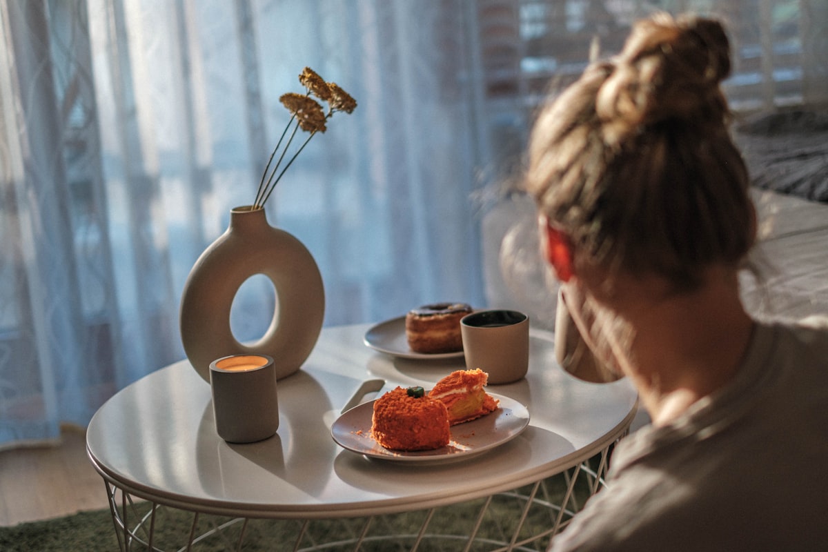 a woman sitting at a table with a plate of food related to Dreamy Slumber: Top Picks for IKEA Kids Beds