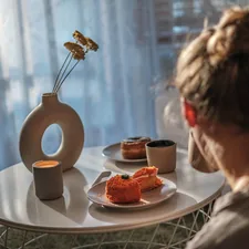 a woman sitting at a table with a plate of food related to Dreamy Slumber: Top Picks for IKEA Kids Beds