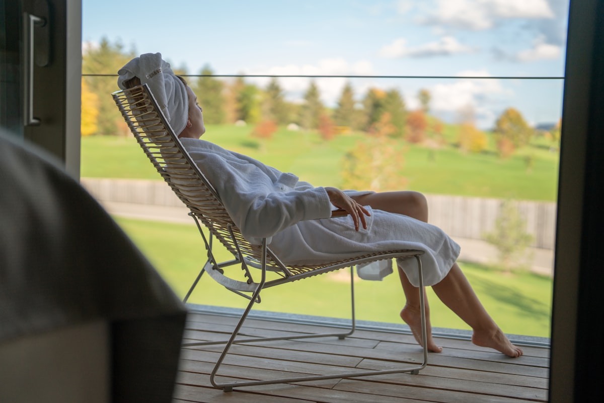 a woman sitting in a chair looking out a window related to Escape to Serenity: Discover the Ultimate Bed and Breakfast Spa Experience