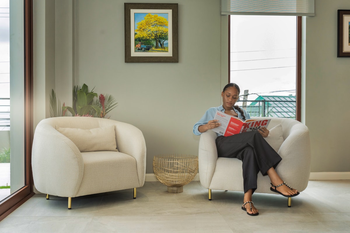 a woman sitting in a chair reading a magazine related to Elevate Your Space with Stylish Wide Rod Valances