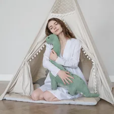 a woman sitting in a teepee holding a stuffed animal related to Bring Prehistoric Fun to Your Bedroom with Dinosaur Bedding Sets