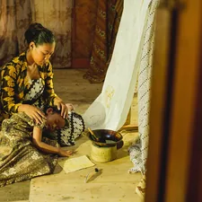 a woman sitting on the floor with a child related to Embracing Comfort and Tradition: The Enduring Appeal of Legacy Home Bedding