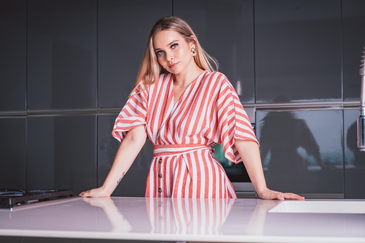 A woman standing by the kitchen related to Red Kitchen Valance: A Pop of Color for Your Kitchen