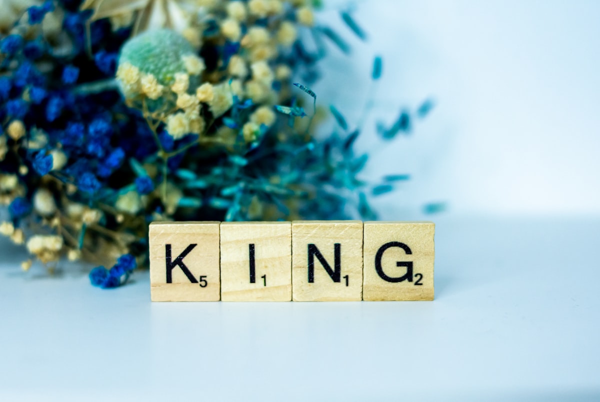 a wooden block that says king next to a bouquet of flowers related to Choose the Perfect King Size Quilt Coverlet for Your Bedroom Oasis