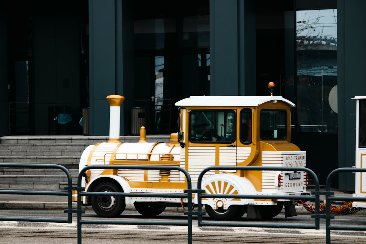 a yellow and white truck parked in front of a building related to Affordable Train Toddler Bed