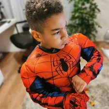 a young boy wearing a spider man costume related to Transform Your Child's Room with a Heroic Bed