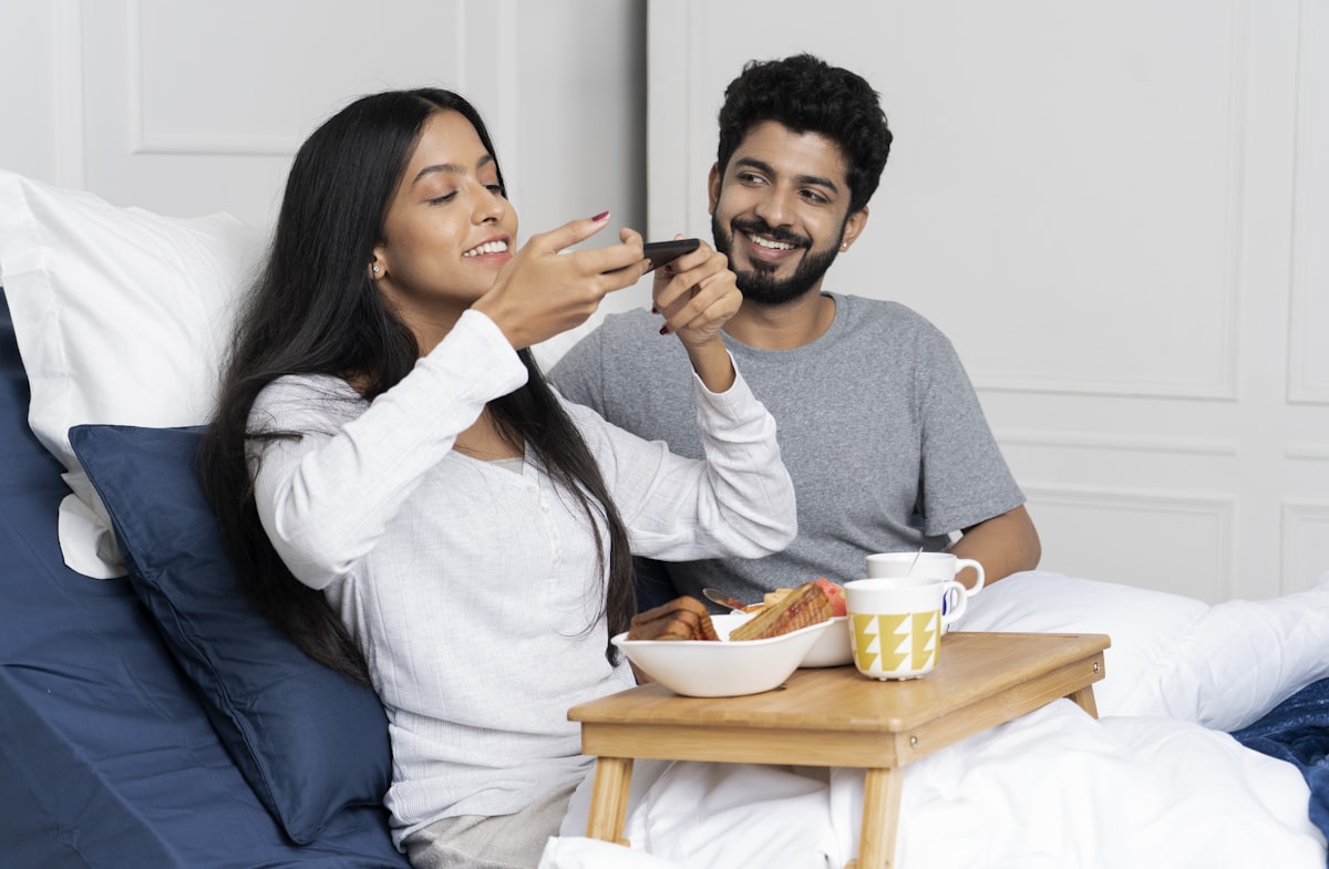 A young couple having breakfast in an adjustable bed related to Elevate Your Sleep: The Unexpected Benefits of a Bed Wedge Pillow